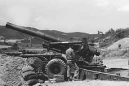 Lieutenant Bevin Alexander beside an 8-inch howitzer