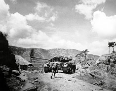 Marines seek cover behind an M26 Pershing tank