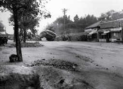 An army M4A3 Sherman tank clears a gap in a barricade