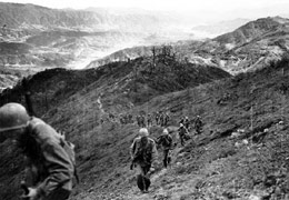 Men of the 9th Infantry Regiment climb a steep slope on Bloody Ridge