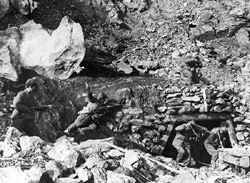 Red Chinese soldiers cover Americans emerging from a cave to surrender